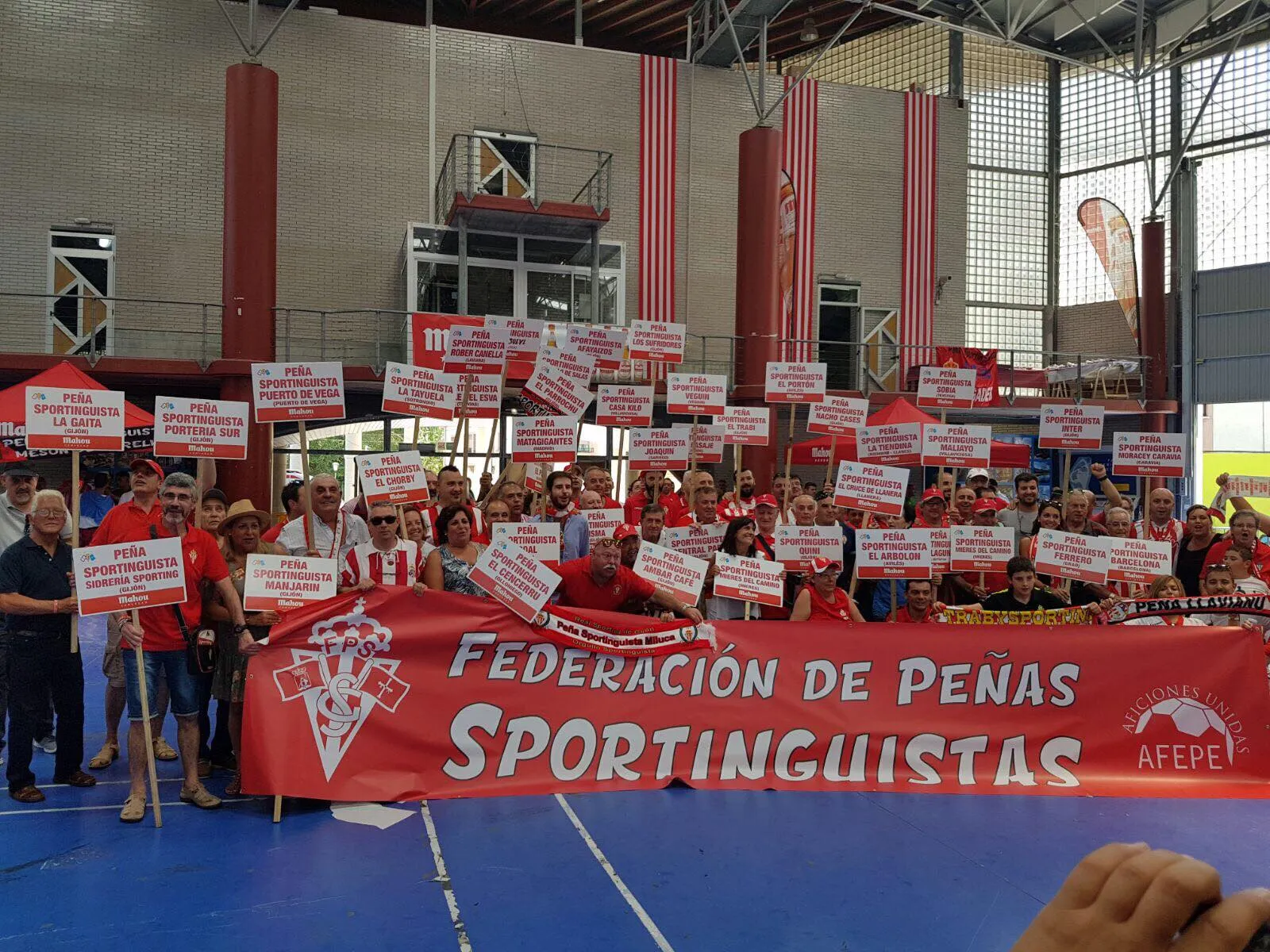 Foto de peñistas con carteles con el nombre de su peña